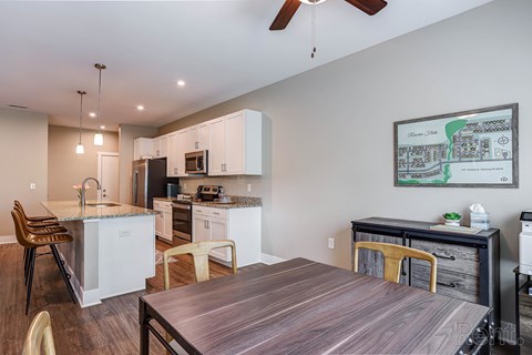 A modern kitchen with a wooden table and chairs.