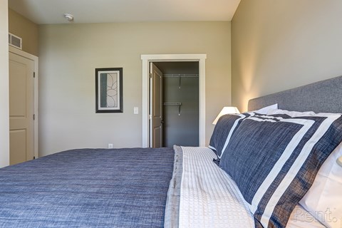 A bedroom with a bed and a picture on the wall.