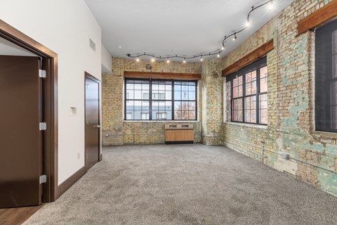 A room with a brick wall and a brown door.
