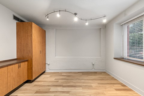 A room with wooden floors and a window with blinds.
