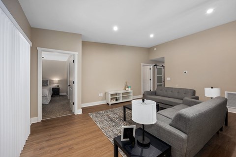 A living room with a grey couch and a black coffee table.