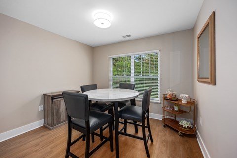 A dining room with a table and chairs.