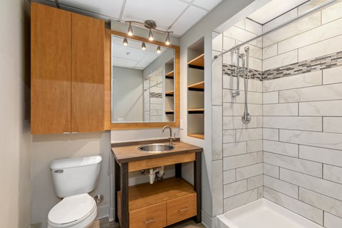 A bathroom with a toilet, sink, and a mirror.