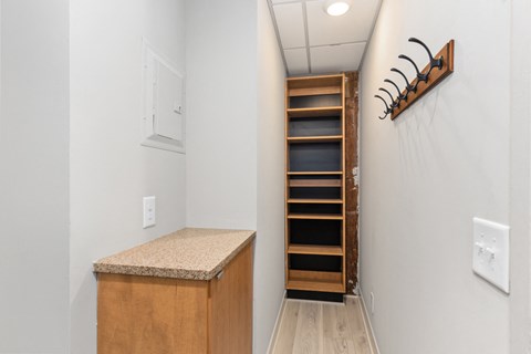 A white hallway with a wooden cabinet and a rack on the wall.