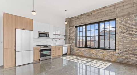 an open kitchen with a brick wall and a large window