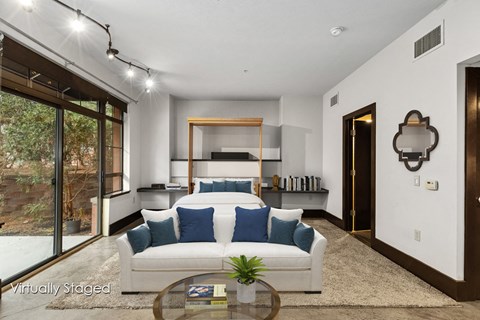 A living room with a white couch and a glass coffee table.