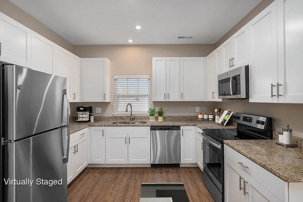 a kitchen with white cabinets and stainless steel appliances