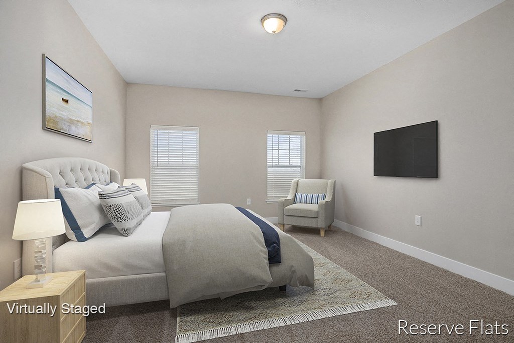 a white bedroom with a bed and a tv