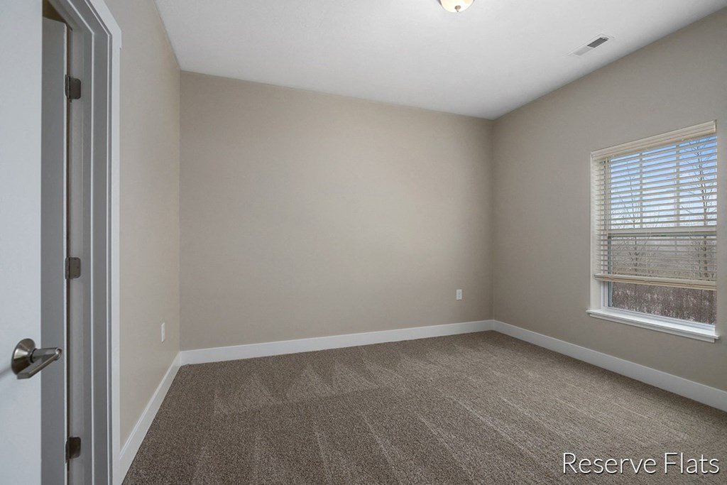 an empty room with a window and a door