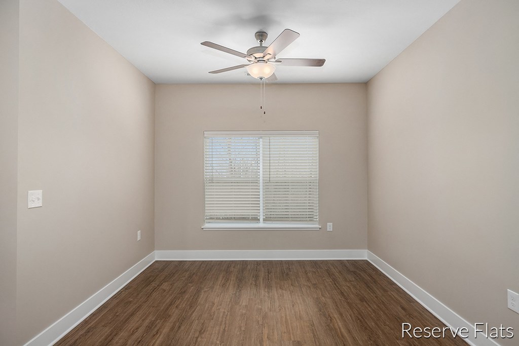 a empty room with a ceiling fan and a window