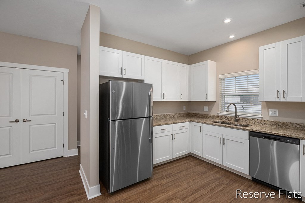 a kitchen with white cabinets and a stainless steel refrigerator