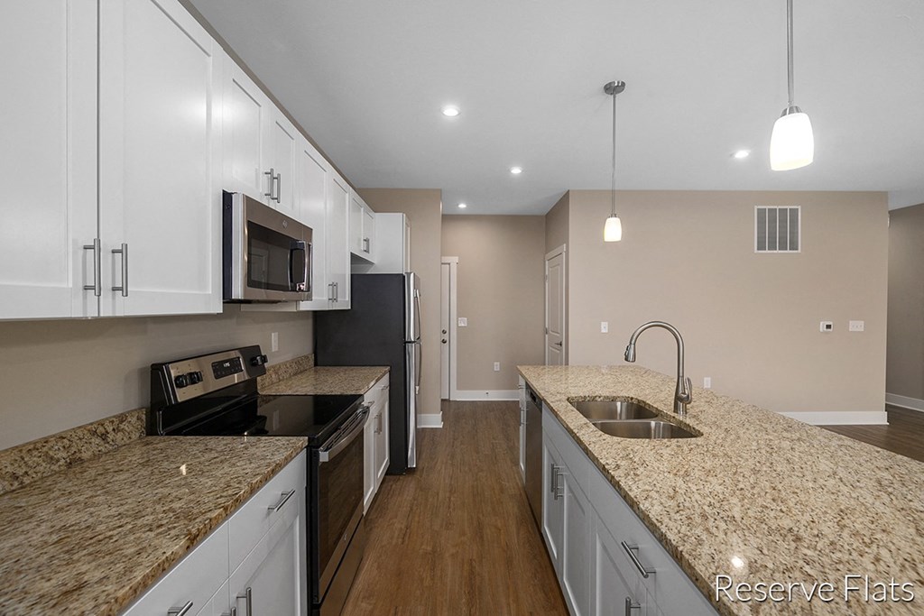 a kitchen with granite counter tops and white cabinets