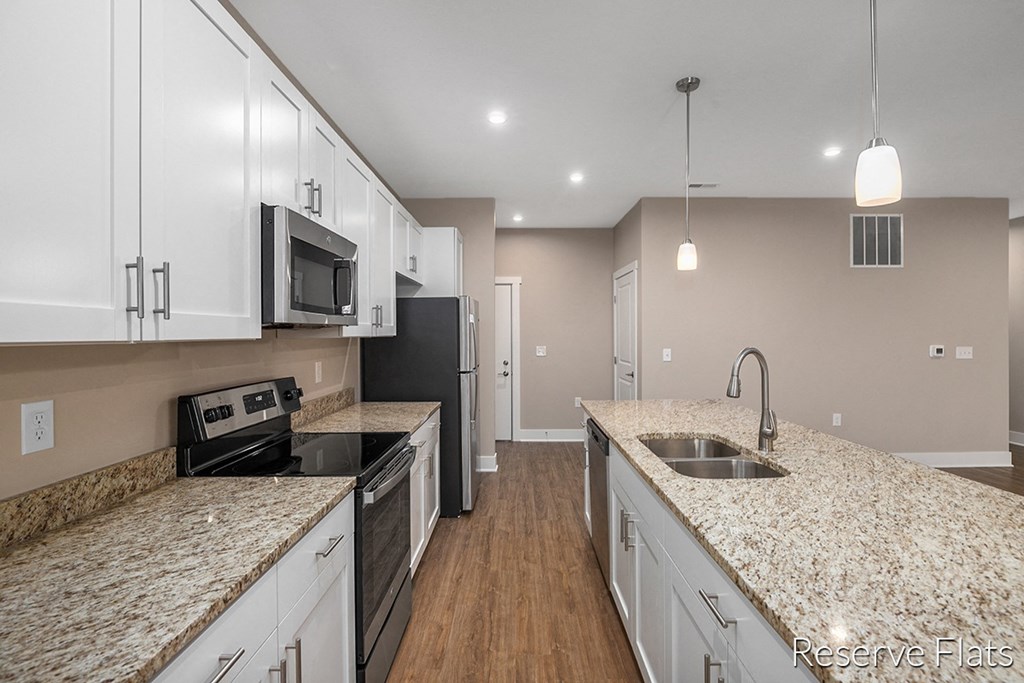 a kitchen with granite counter tops and white cabinets