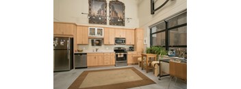 A kitchen with wooden cabinets and a rug on the floor.