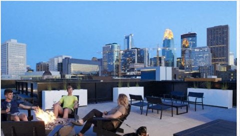 a group of people sitting around a fire on a rooftop