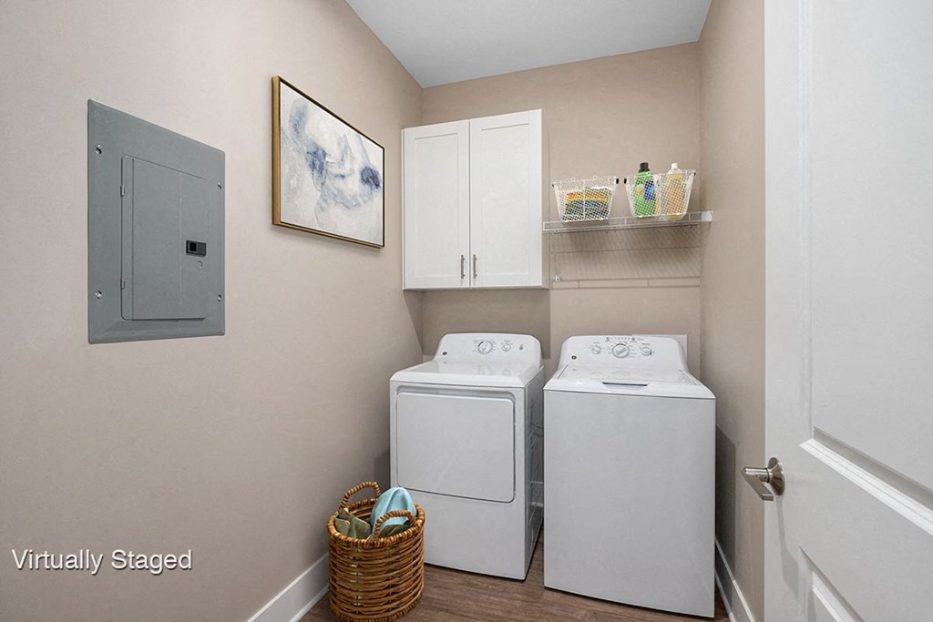 a washer and dryer in a laundry room with white cabinets