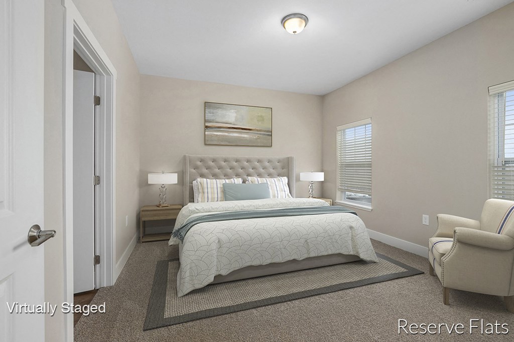 a bedroom with a bed and a chair and a door