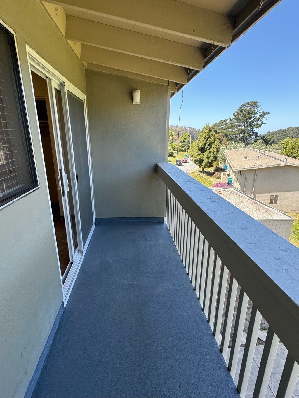 a large balcony with a view of a yard and a house