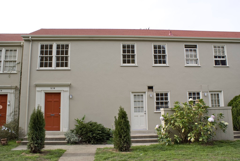 the front of a white building with a red door