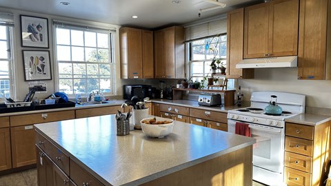 A kitchen with a large island in the middle and wooden cabinets.