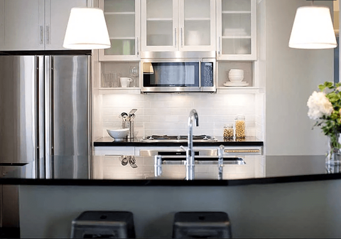 A modern kitchen with a stainless steel refrigerator and a microwave above the stove.