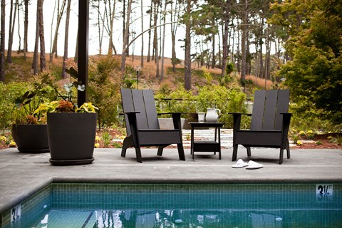 A pool with a table and chairs around it.