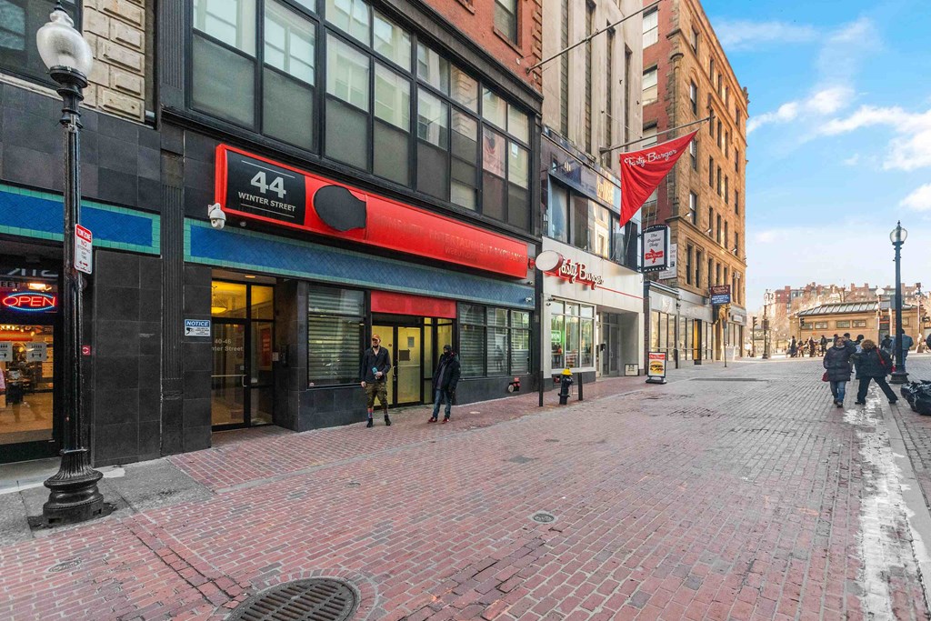 people walking down a street in front of a building