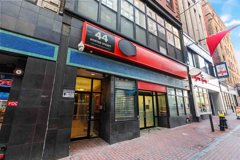 a building with a red sign on the side of a street
