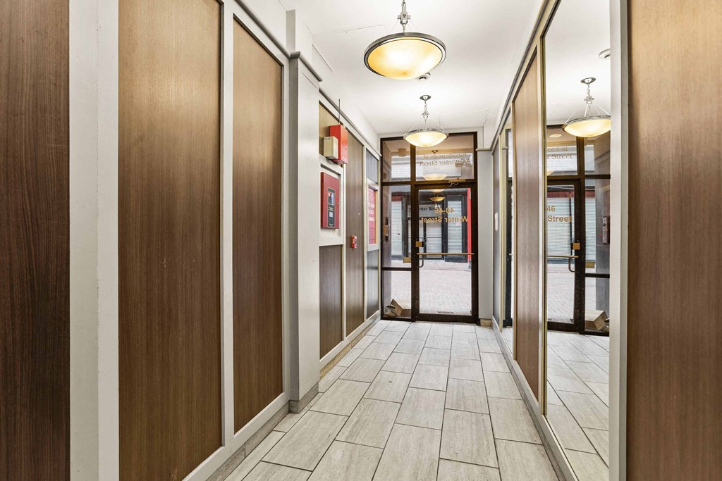 a hallway with wood paneled walls and a tile floor