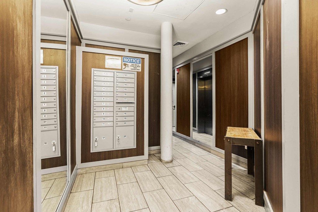 a hallway with mailboxes and a table in a lobby