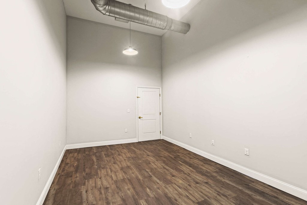 an empty living room with white walls and wood floors