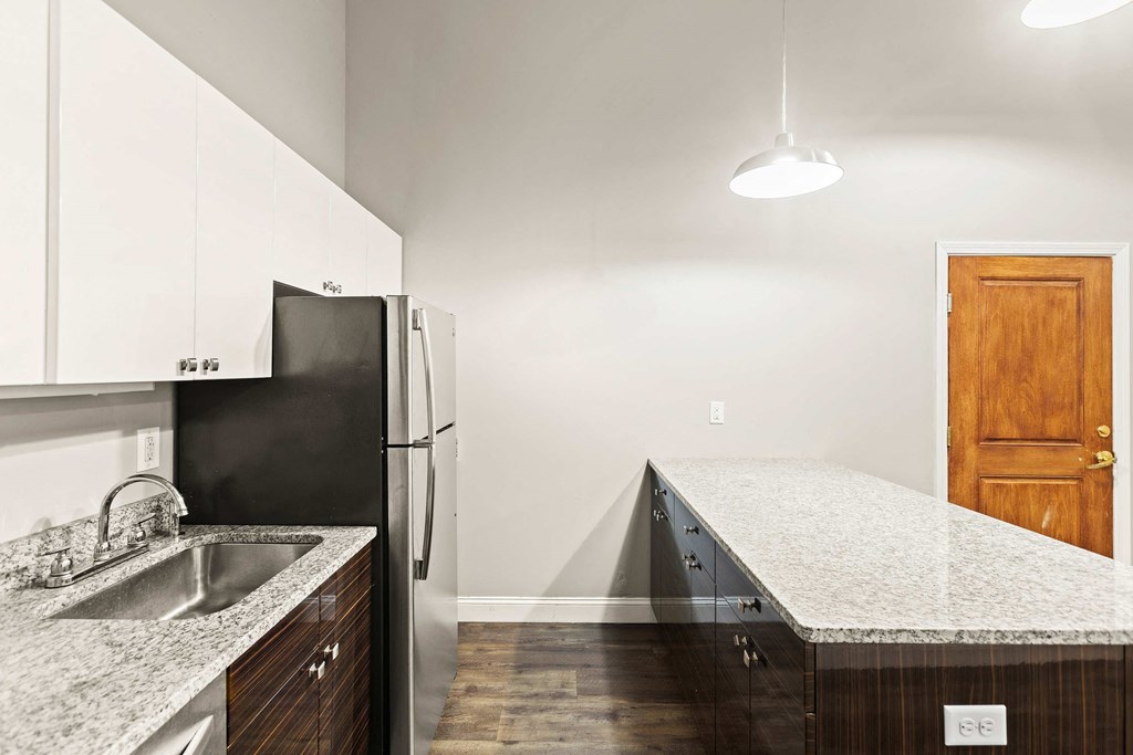 a kitchen with granite counter tops and a refrigerator