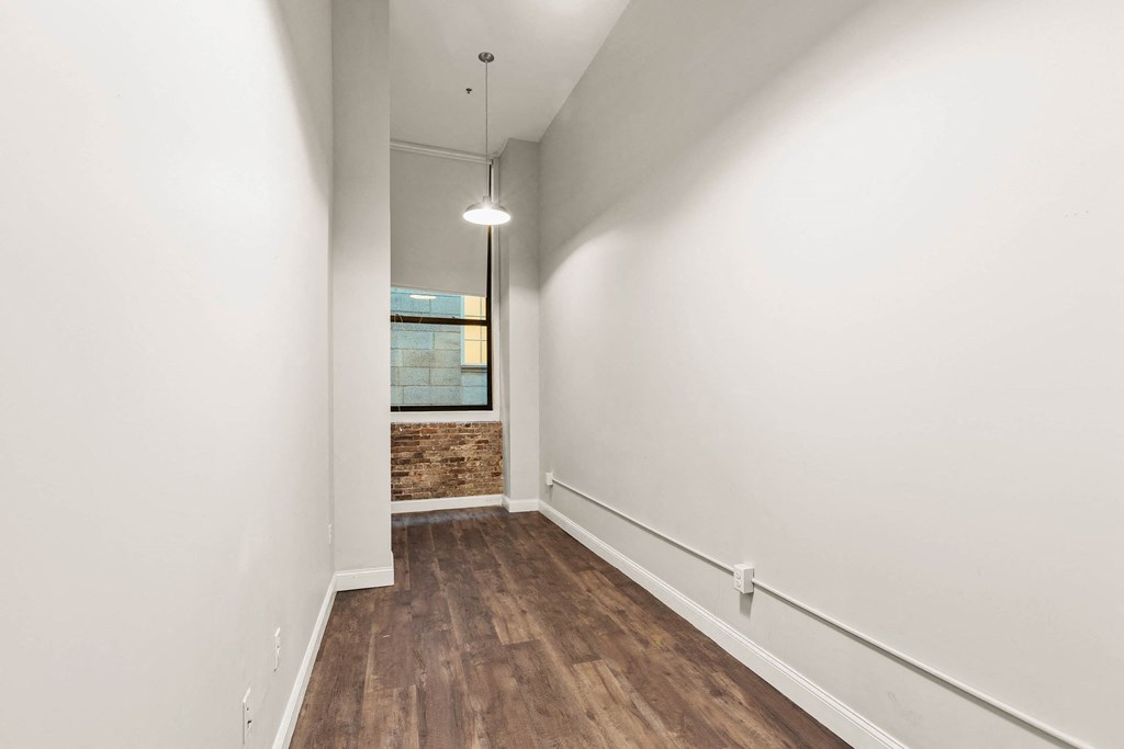 a living room with white walls and wood floors