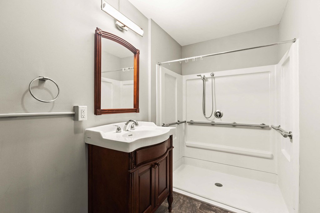 a bathroom with a shower and a sink and a mirror