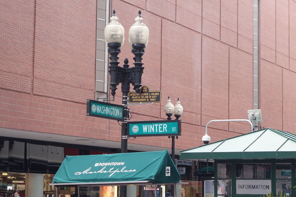 a street light with street signs in front of a building