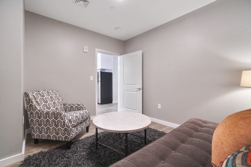 a living room with grey walls and a brown couch