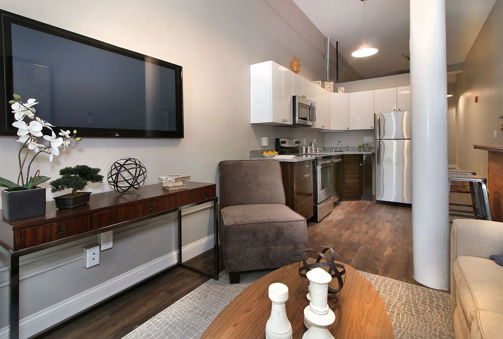 a living room and kitchen with a tv and a table