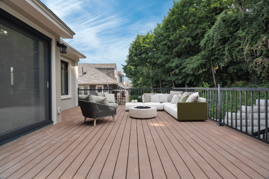 a deck with a couch and a fire pit on it