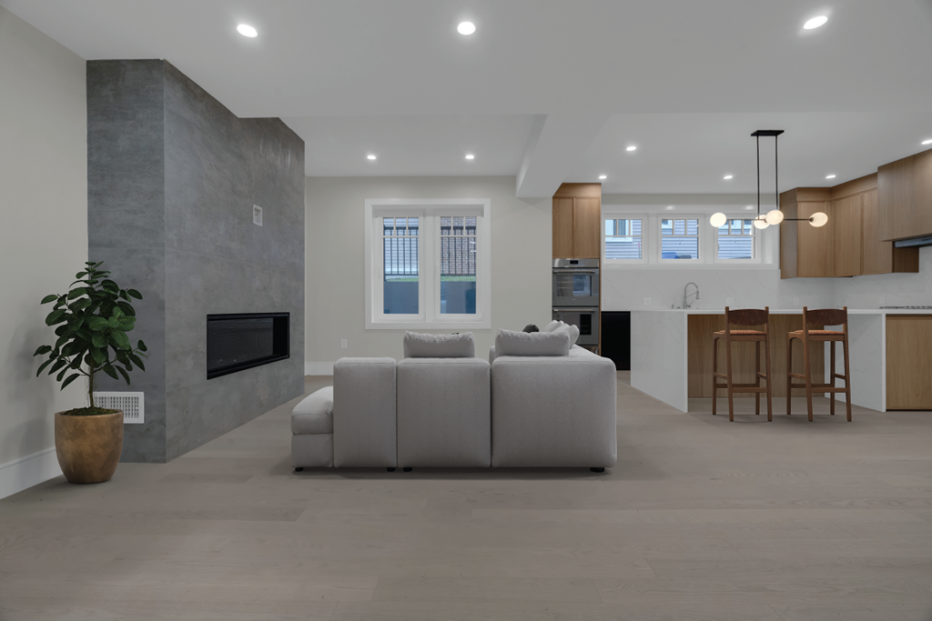 a white living room with a white couch and a kitchen