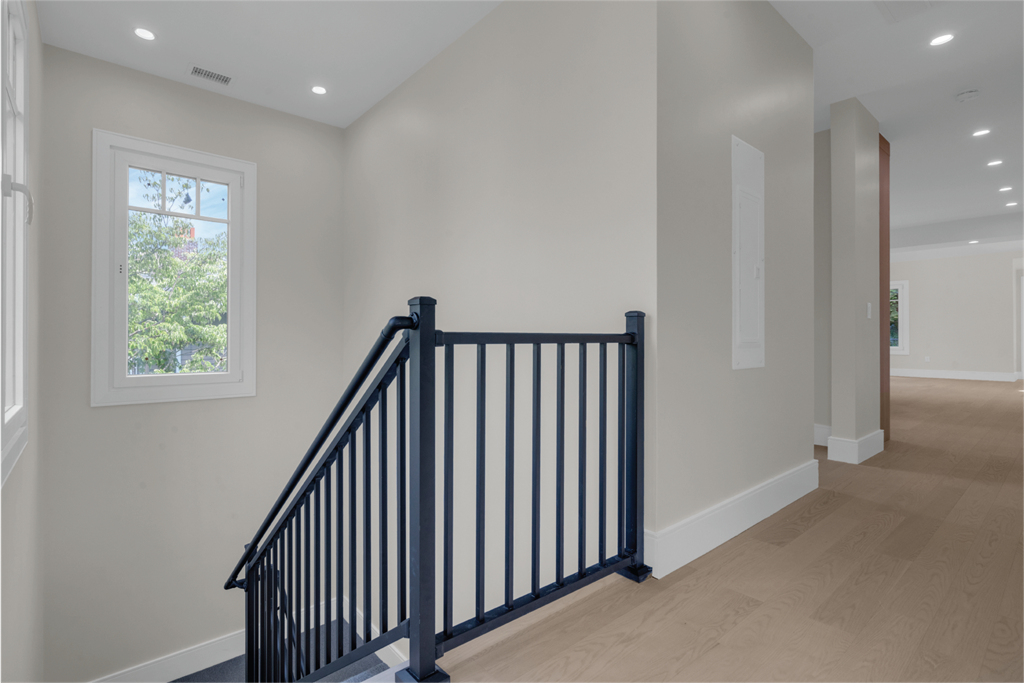 a staircase in a home with white walls and wood floors