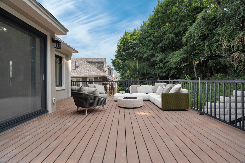 a backyard deck with a couch and chairs and a fire pit