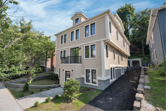 the back of a house with a yard and a sidewalk