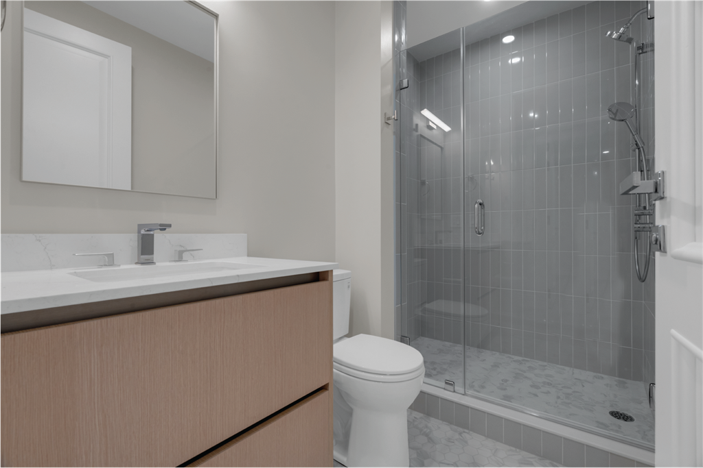 a bathroom with a shower and a sink and a toilet