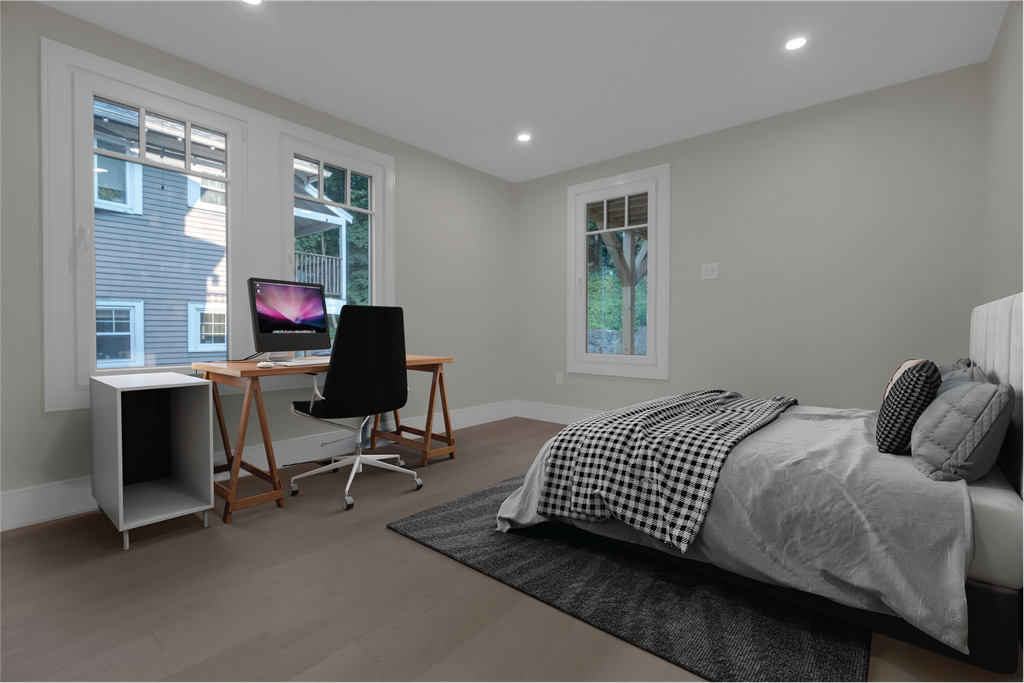 a bedroom with a bed and a desk with a computer