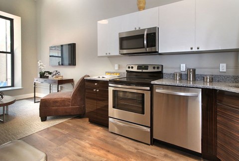 a kitchen with stainless steel appliances and a living room with a couch