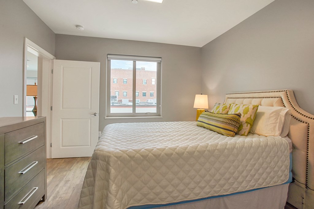 a bedroom with a large bed and a window