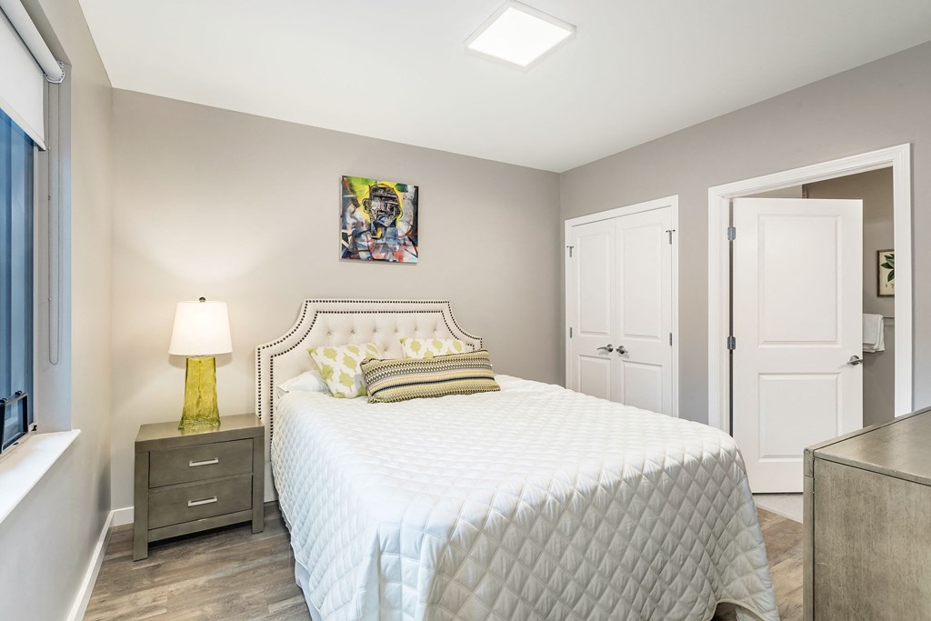a bedroom with a white bed and a closet