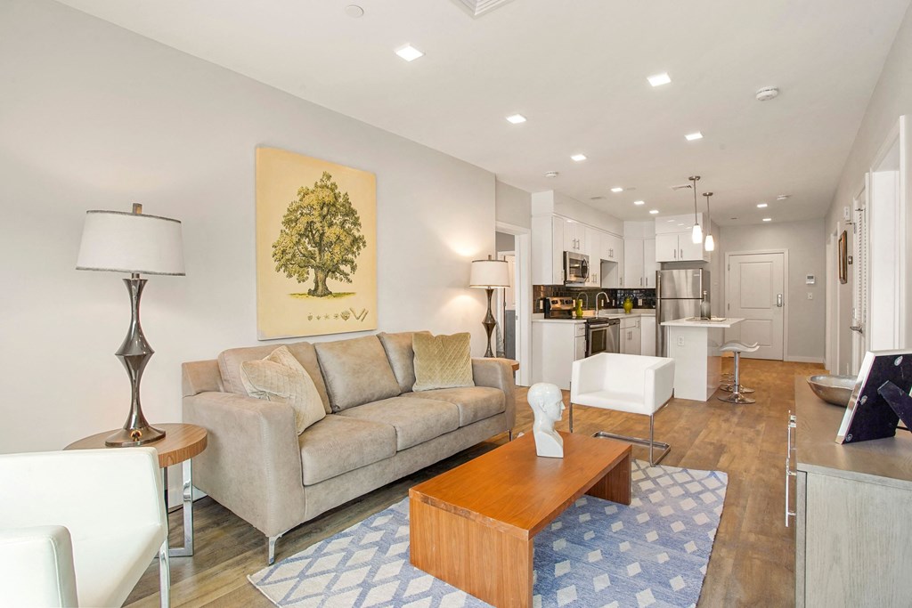 a living room with a couch and a coffee table in front of a kitchen