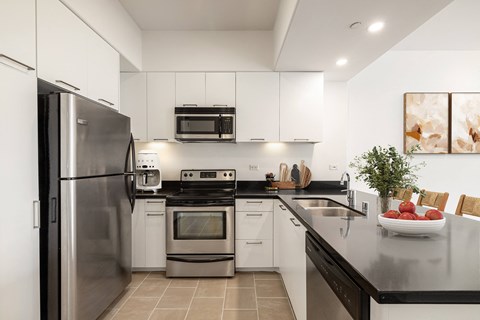 a modern kitchen with stainless steel appliances and black counter tops