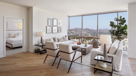 a living room with a view of the city and a couch and chairs